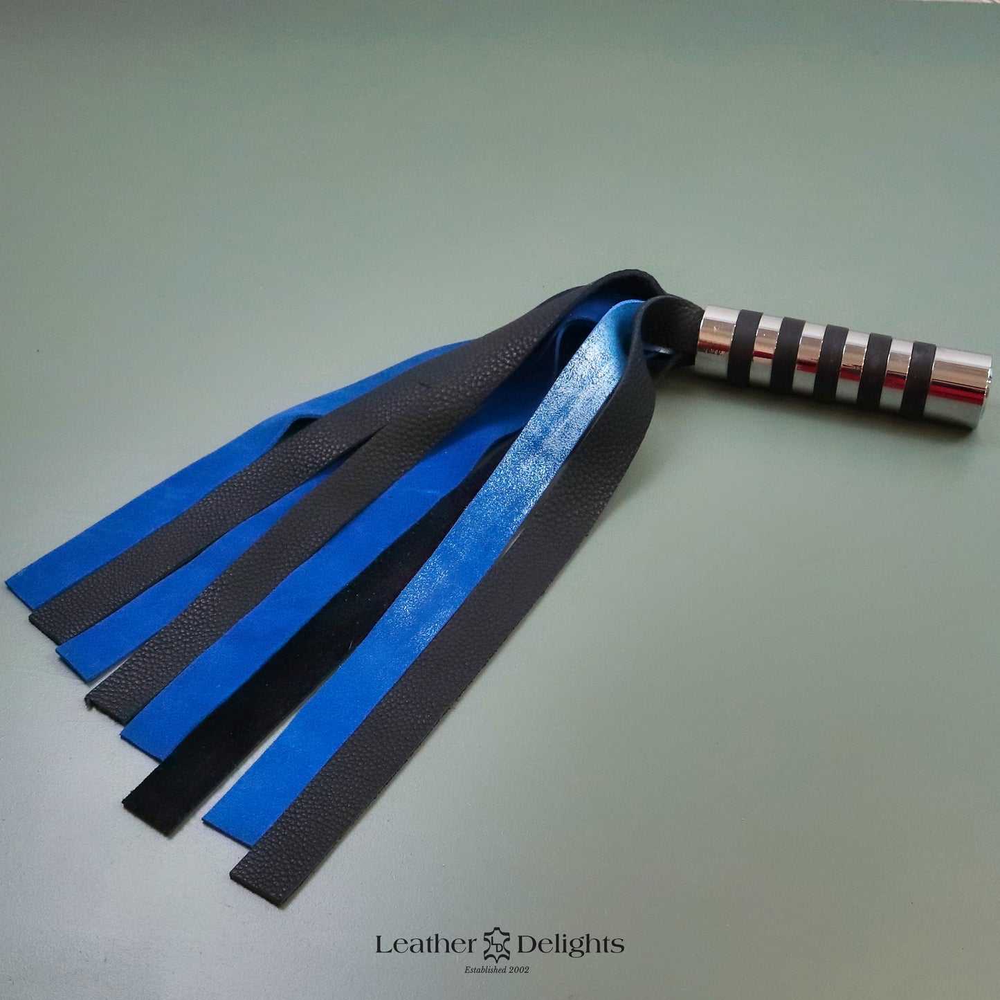 Angelaufene Peitsche aus metallisch blauem Wildleder und schwarzem Leder mit silbernem Griff